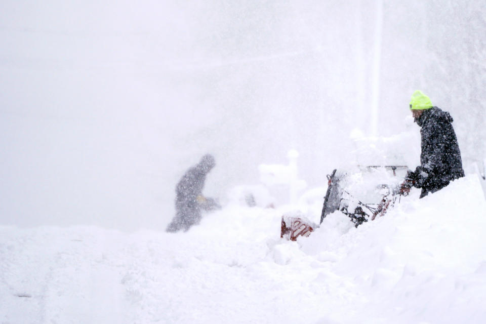 In near whiteout conditions, neighbors clear their driveways, Tuesday, March 14, 2023, in East Derry, N.H. By the time the winter storm wraps up Wednesday, snow totals in New England are expected to reach a couple of feet of snow in higher elevations to several inches along the coast. (AP Photo/Charles Krupa)