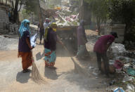 Indian municipal workers cleans the residential area of positive coronavirus patent at Mahindra Hills in Hyderabad.