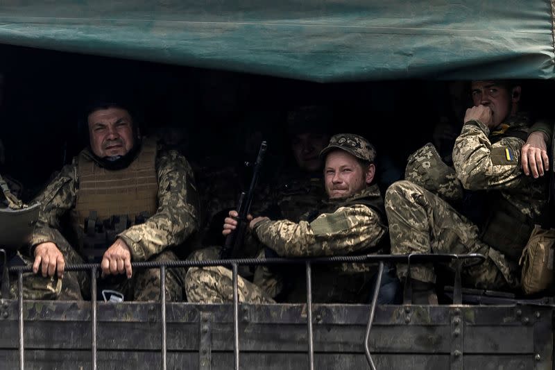 Service members of the Ukrainian armed forces travel on a military vehicle, amid Russia's invasion, near the town of Bakhmut