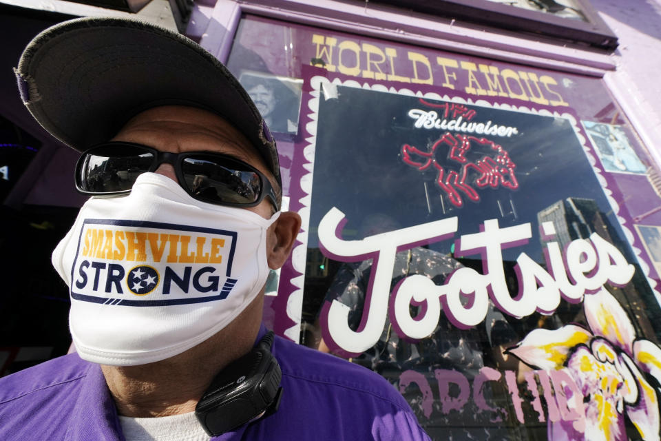 Jeffrey Susan, a security guard at Tootsies Orchid Lounge, wears a Nashville Strong face mask as he stands outside the famous honky-tonk Tuesday, Dec. 29, 2020, in Nashville, Tenn. The Christmas Day explosion near the center of the tourist area has sparked shock across the city and the country. Officials have named 63-year-old Anthony Quinn Warner as the man behind the Christmas Day explosion in which he was killed, but the motive has remained elusive. (AP Photo/Mark Humphrey)