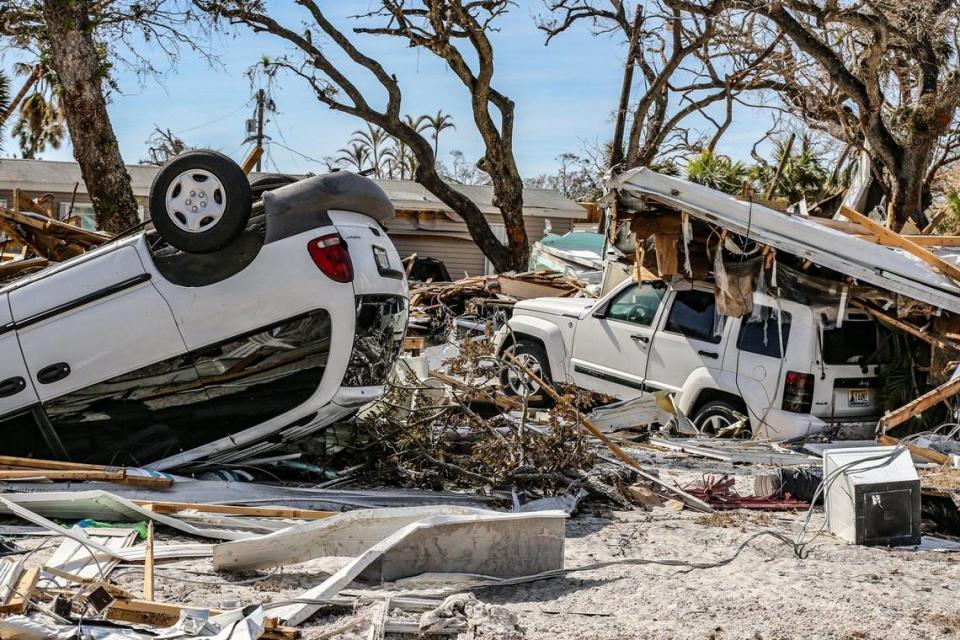 Damaged cars lay among the debris of homes destroyed by Hurricane Ian on Fort Myers Beach on Monday, Oct. 3, 2022.
