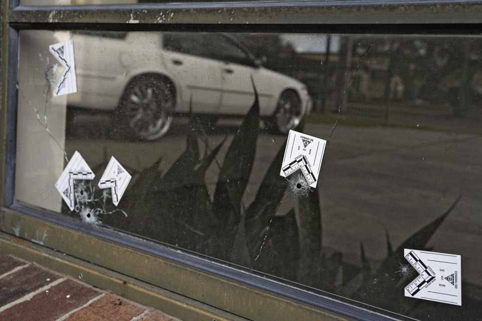 Bullet holes are shown in a window across the street from a shooting location Tuesday, Jan. 31, 2023, in Lakeland, Fla. Police say several people were shot and wounded during a drive-by shooting in a central Florida neighborhood. (AP Photo/Chris O'Meara)