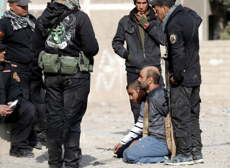 FILE PHOTO - Members of an Iraqi Special forces intelligence team talk to suspected Islamic State fighters in Mosul, Iraq November 27, 2016. REUTERS/Goran Tomasevic/File Photo