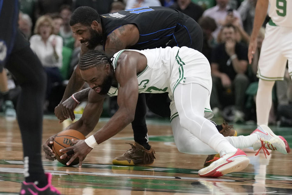 Boston Celtics guard Jaylen Brown, fornt, and Dallas Mavericks guard Kyrie Irving vie for the ball during the first half of Game 1 of basketball's NBA Finals, Thursday, June 6, 2024, in Boston. (AP Photo/Charles Krupa)