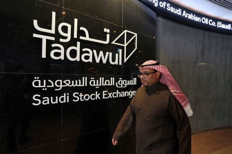 Man walks at the Saudi Stock Exchange (Tadawul) following the debut of Saudi Aramco's IPO on the Riyadh's stock market, in Riyadh