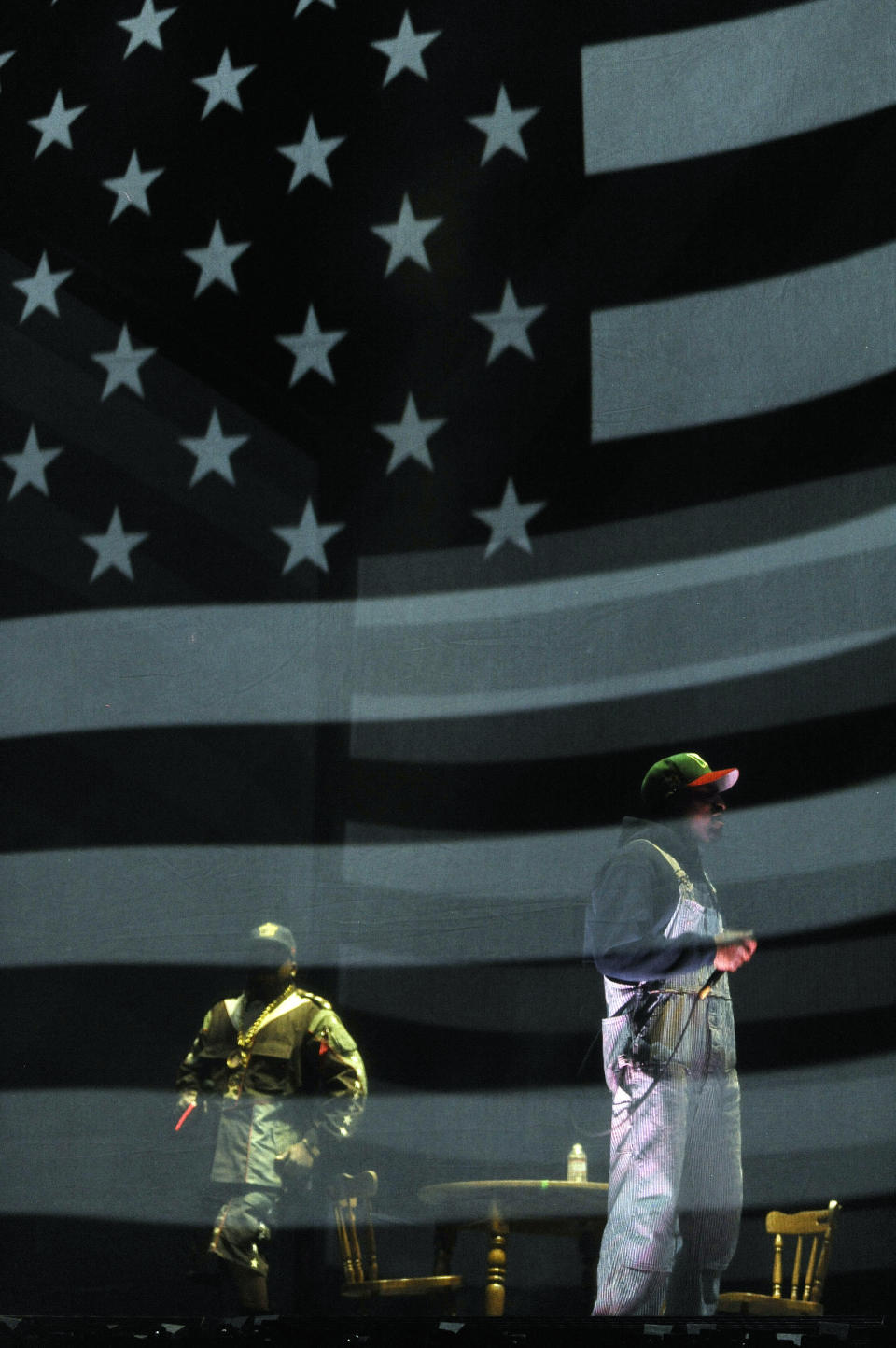 Big Boi, left, and Andre 3000 of hip hop group Outkast perform behind a screen depicting the American flag during their headlining set on the first day of the 2014 Coachella Music and Arts Festival on Friday, April 11, 2014, in Indio, Calif. (Photo by Chris Pizzello/Invision/AP)