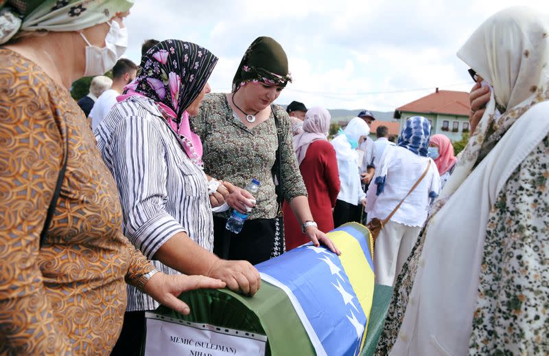 Bosnian Muslims attend a collective funeral in Kamicani