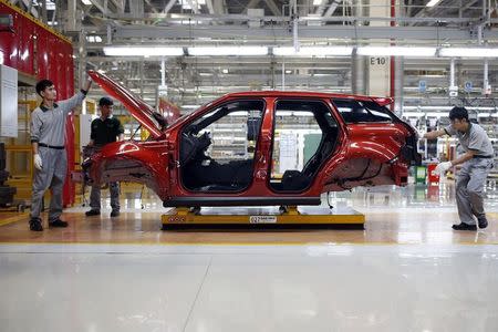 Employees work at the production line inside the Chery Jaguar Land Rover plant before the plant opening ceremony in Changshu, Jiangsu province, October 21, 2014. REUTERS/Aly Song/Files