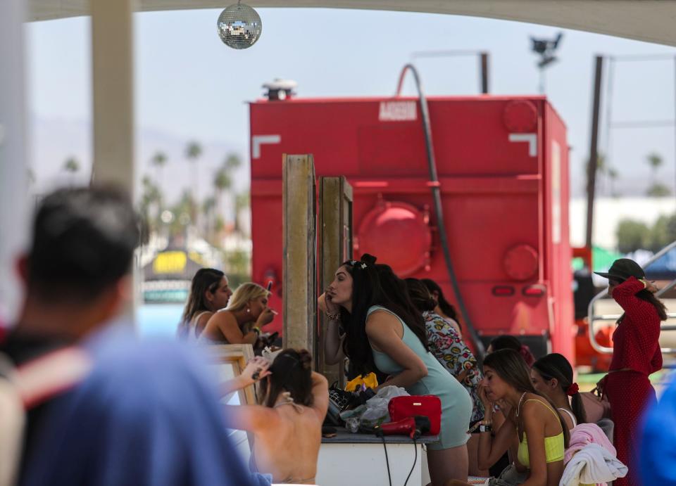 Festival goers use one of the camp shower areas to get ready for the day at the Coachella Valley Music and Arts Festival in Indio, Calif., Sunday, April 17, 2022. 