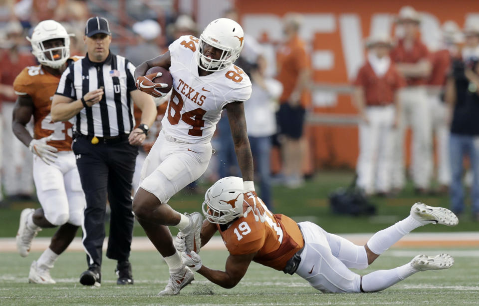 Texas wide receiver Lil’Jordan Humphrey (84) leaps out of the grasp of Texas Longhorns defensive back Brandon Jones (19) during the team’s Orange-White intrasquad spring college football game, Saturday, April 21, 2018, in Austin, Texas. (AP Photo/Eric Gay)