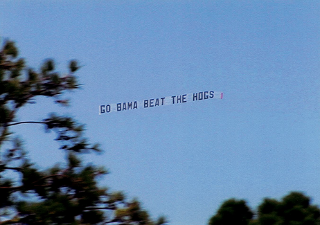 A "Go Bama Beat the Hogs" banner flies over a golf course in Arkansas the weekend of an Alabama-Arkansas football game. Trustee Jim Wilson made it happen.