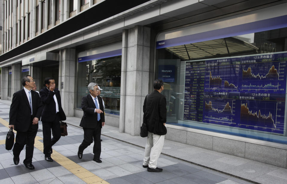  <p> Passers-by check the electronic stock indicator of a securities frim in Tokyo Wednesday, May 23, 2012. Japan's Nikkei 225 index fell 1.98 percent to 8,556.60 as a report that Greece is considering preparations to leave the euro common currency sent Asian stock markets lower Wednesday. (AP Photo/Shizuo Kambayashi) </p>