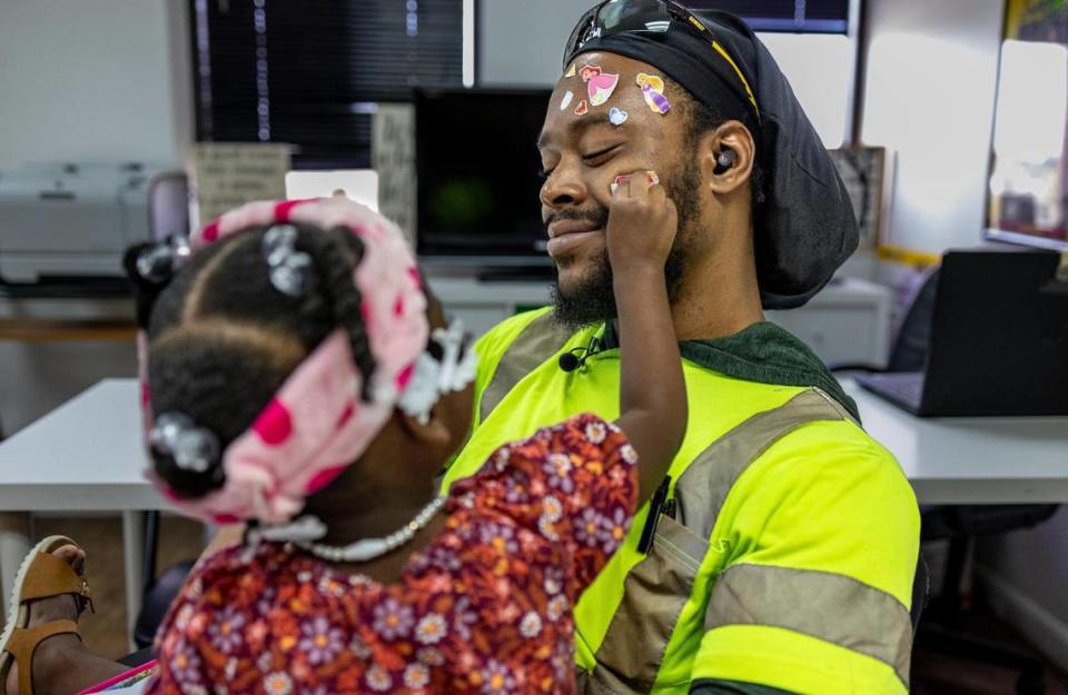 Breon Williams has his face covered with stickers by his 2-year-old daughter Da’Nasia Williams at Children of Inmates offices in Northwest Miami-Dade.
