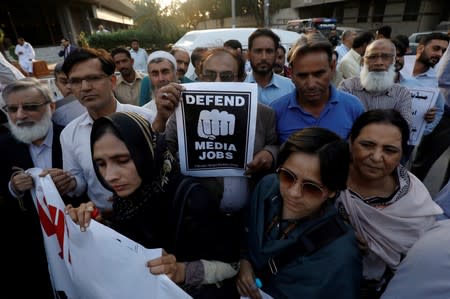 FILE PHOTO: Journalists chant slogans during a rally protest which they say is against layoffs and the non-payment of salaries, in Karachi