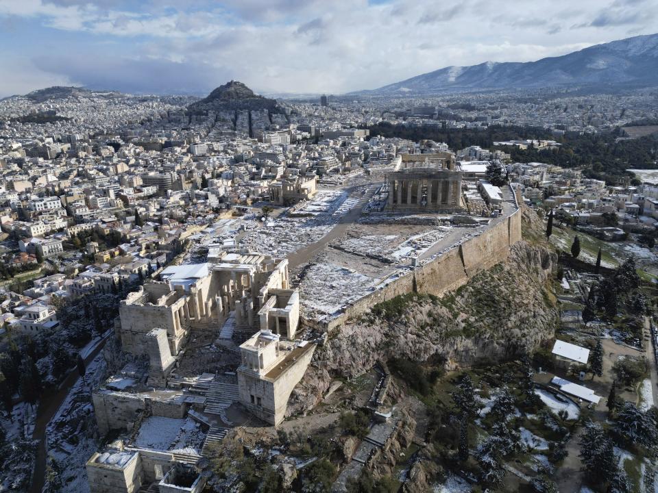 FILE - Parts of the Acropolis are covered in snow as the Parthenon temple stands atop of the ancient hill after a snowfall in Athens, Greece, on Feb. 6, 2023. Greece's prime minister said Thursday May 11, 2023 his government is exploring a “win-win” solution to one of the world’s most intractable cultural heritage disputes: The fate of the Parthenon Sculptures currently in the British Museum. But he rules out any deal that would include the word “loan.” (AP Photo/Thanassis Stavrakis, File)