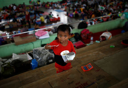 A child eats noodles at a temporary evacuation center for people living near Mount Agung, a volcano on the highest alert level, inside a sports arena in Klungkung, on the resort island of Bali, Indonesia, September 24, 2017. REUTERS/Darren Whiteside