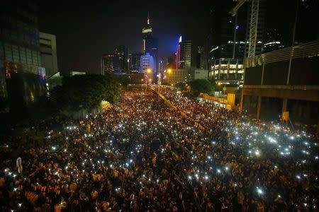 Protesters hold their mobile phones as they block the main street to the financial Central district, outside the government headquarters, in Hong Kong September 29, 2014. REUTERS/Carlos Barria