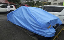 <p>A car under a blue cover, which the murder suspect apparently drove to the police station after he killed a number of people and injured dozens injured in a knife attack at facility for the diabled, is parked at the Tsukui Police Station in Sagamihara, outside Tokyo, Japan, Tuesday, July 26, 2016. (AP Photo/Mari Yamaguchi)</p>