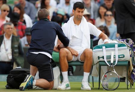Serbia's Novak Djokovic receives medical attention during his quarter final match against Czech Republic's Tomas Berdych. REUTERS/Matthew Childs