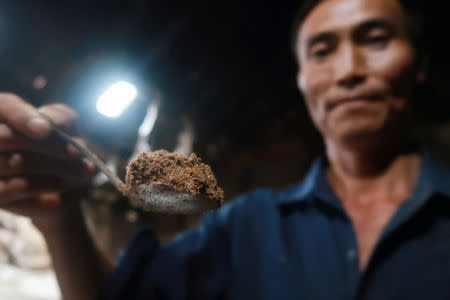 Chen Qianjiang shows a spoonful of powder made of cockroaches to the camera at his home in Changning county, Sichuan province, China August 11, 2018. REUTERS/Thomas Suen