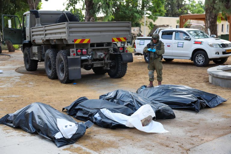 Un soldado israelí se prepara para retirar los cuerpos de su compatriota, muerto durante un ataque de militantes palestinos, en Kfar Aza, al sur de Israel, en la frontera con la Franja de Gaza, el 10 de octubre de 2023