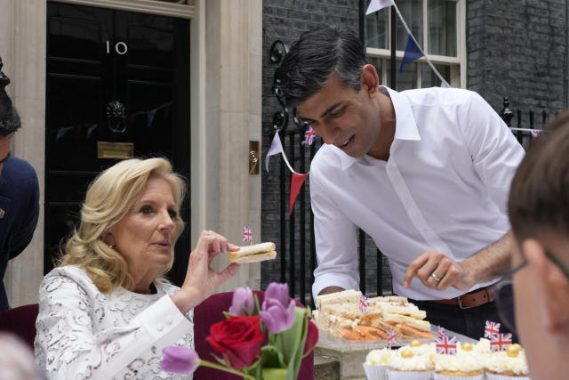 Prime Minister Rishi Sunak holds a plate of sandwiches as US First Lady Jill Biden take one with a British flag in it as they attend the Big Lunch party at Downing Street in London Sunday, May 7, 2023. The Big Lunch is part of the weekend of celebrations for the Coronation of King Charles III. Guests at the big lunch include community heroes and Ukrainians displaced by the war, and youth groups. (AP Photo/Frank Augstein, Pool)