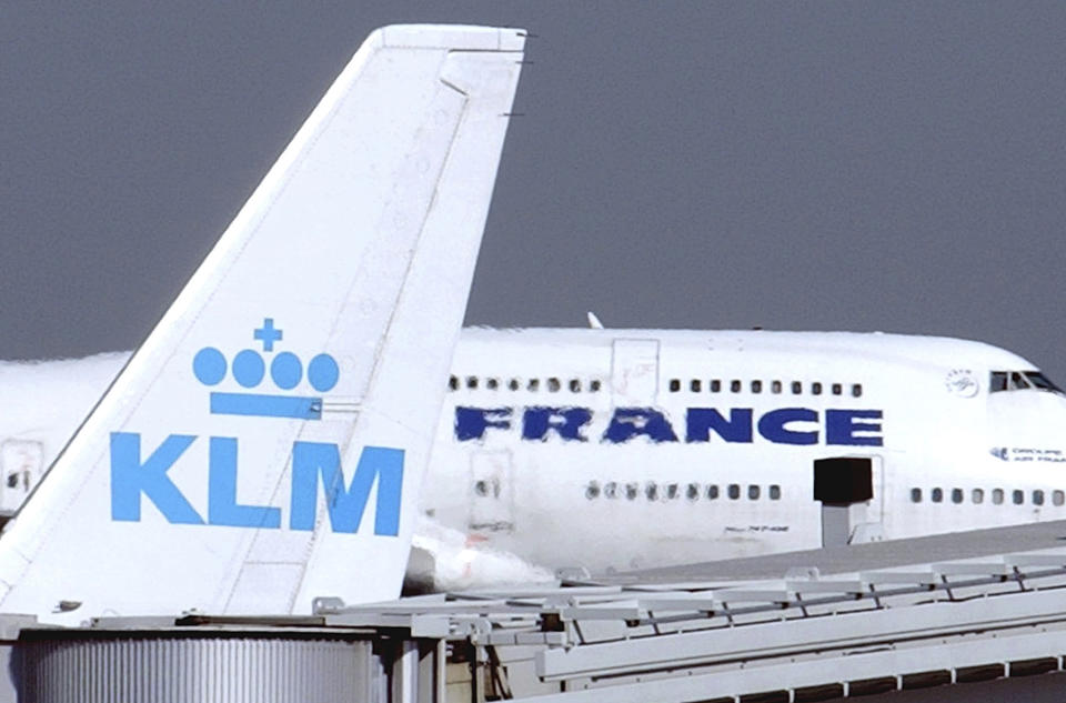 FILE - In this Sept. 30, 2003 file photo, an Air France jumbo jet rolls behind the tail of a KLM Royal Dutch airliner at Charles de Gaulle airport in Roissy, north of Paris. Air France-KLM plunged to a 7.1 billion euro ($8.5 billion) loss in 2020 as the global pandemic grounded planes and halted travel plans worldwide causing a 67% slump in passenger numbers at the French-Dutch aviation giant. (AP Photo/Remy de la Mauviniere, File)