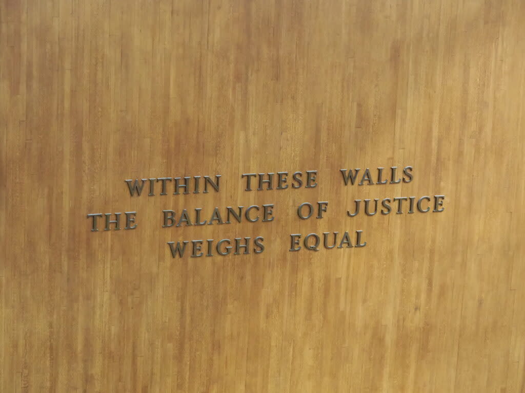 The Kansas Supreme Court, which conducts business in a building with this message embedded on an interior wall, revoked the state certification of court reporter Jessica Belcher. She was accused of blackmail and physical abuse, but didn't cooperate with the state ethics investigation. (Tim Carpenter/Kansas Reflector)
