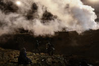 Migrants run as tear gas is thrown by U.S. Border Protection officers to the Mexican side of the border fence after they climbed the fence to get to San Diego, Calif., from Tijuana, Mexico, Tuesday, Jan. 1, 2019. Discouraged by the long wait to apply for asylum through official ports of entry, many migrants from recent caravans are choosing to cross the U.S. border wall and hand themselves in to border patrol agents. (AP Photo/Daniel Ochoa de Olza)