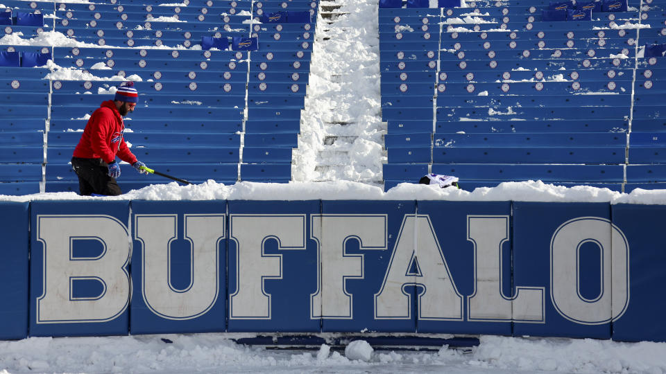 A stadium worker clears snow from seats before an NFL wild-card playoff football game between the Buffalo Bills and the Pittsburgh Steelers, Monday, Jan. 15, 2024, in Buffalo, N.Y. (AP Photo/Jeffrey T. Barnes)