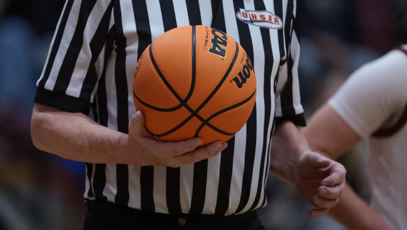 A referee holds the ball during a high school basketball game on Tuesday, Dec. 12, 2023.