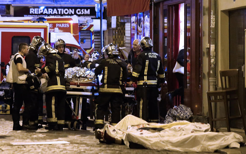 FILE - In this Friday, Nov. 13, 2015 file photo, rescue workers tend to victims outside a cafe in the 10th district of Paris. France is commemorating the fourth anniversary of the Islamic State attacks in Paris. The attacks on Nov. 13, 2015, left 131 people dead at the country's national stadium, the Bataclan concert hall and bars and restaurants in the city center. (AP Photo/Jacques Brinon, file)