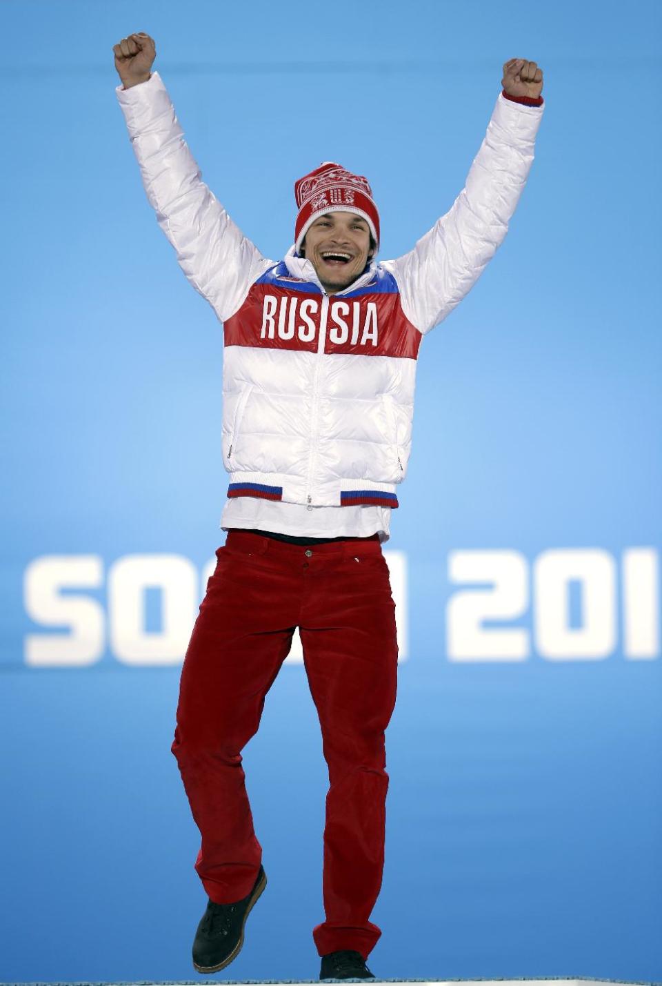 Vic Wild of Russia, the gold medalist in the men's snowboard parallel giant slalom, celebrates during the medals ceremony at the 2014 Winter Olympics, Wednesday, Feb. 19, 2014, in Sochi, Russia. (AP Photo/David Goldman)