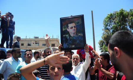 Residents celebrate the army's arrival in the formerly rebel-held town of Ibta, northeast of Deraa city, Syria in this handout released on June 29, 2018. SANA/Handout via REUTERS