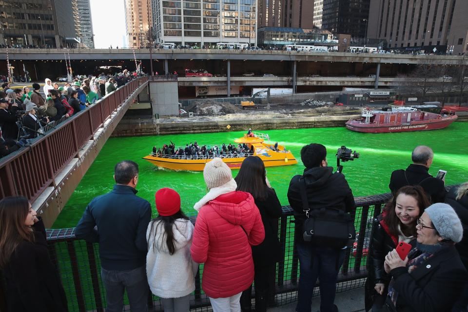 Visitors take pictures after the Chicago River was dyed green in celebration of St. Patrick's day on March 16, 2019 in Chicago, Illinois