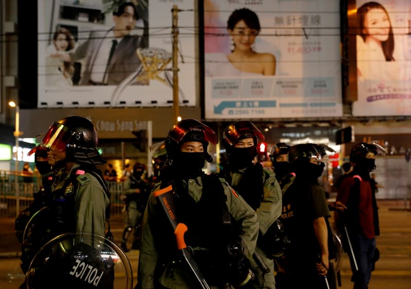 Riot police stand in position to disperse pro-democracy demonstrators gathering to commemorate the three-month anniversary of an assault by more than 100 men on protesters, commuters and journalists, in Hong Kong