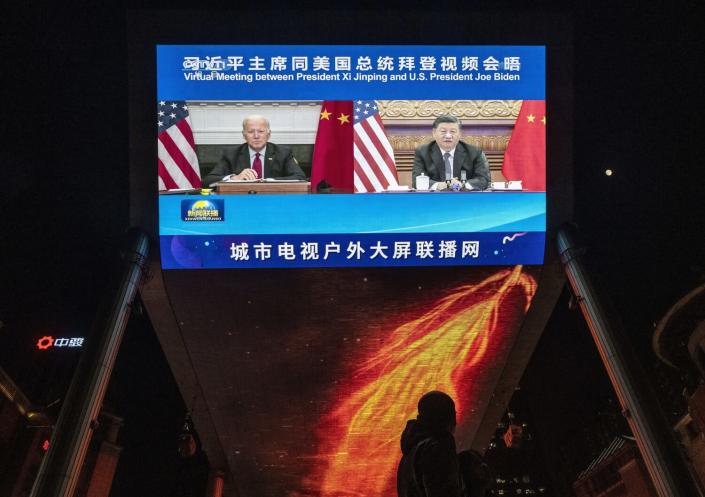 A large screen displays President Biden and China&#39;s President Xi Jinping during a virtual summit