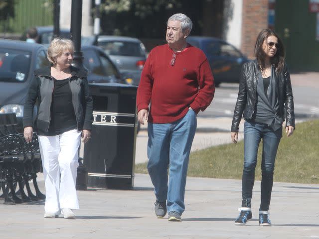 <p>Shutterstock</p> Mila Kunis with her parents, Mark and Elvira, in London in 2013