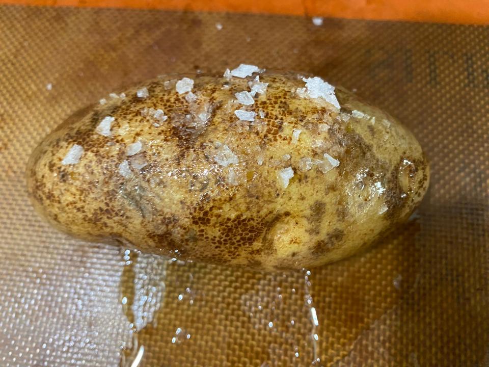 potato covered in salt and oil on a baking tray