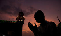 <p>An Indian Muslim offer prayers before breaking his fast on the first day of the holy fasting month of Ramadan at Mecca Masjid in Hyderabad, India, Sunday, May 28, 2017. Islam’s holiest month is a period of intense prayer, dawn-to-dusk fasting and nightly feasts. Just before the fast, Muslims have a pre-dawn meal to get them through the day. Most Muslims break their fast like the Prophet Muhammad did some 1,400 years ago, with a sip of water and some dates at sunset. (Photo: Mahesh Kumar A./AP) </p>