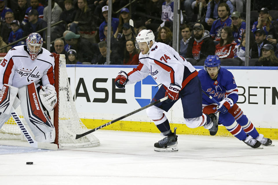 Washington Capitals defenseman John Carlson (74) skates with the puck past goaltender Darcy Kuemper and New York Rangers left wing Artemi Panarin during the first period of an NHL hockey game Wednesday, Dec. 27, 2023, in New York. (AP Photo/Adam Hunger)