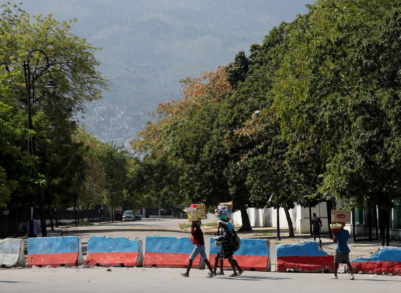 Vendedores ambulantes llevan mercancías a la venta mientras caminan cerca del Palacio Presidencial de Haiti