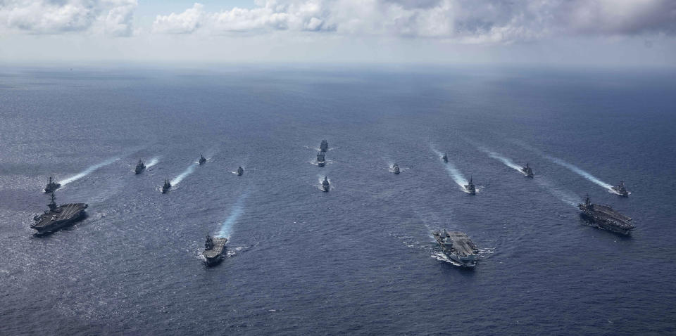 In this photo released by the U.S. Indo-Pacific Command, the United Kingdom's carrier strike group led by HMS Queen Elizabeth (R 08), and Japan Maritime Self-Defense Forces led by (JMSDF) Hyuga-class helicopter destroyer JS Ise (DDH 182) joined with U.S. Navy carrier strike groups led by flagships USS Ronald Reagan (CVN 76) and USS Carl Vinson (CVN 70) sails to conduct multiple carrier strike group operations in the Philippine Sea, on Oct. 3, 2021. After sending a record number of military aircraft to harass Taiwan over China’s National Day holiday weekend, Beijing has toned down the sabre rattling but tensions remain high, with the rhetoric and reasoning behind the exercises unchanged. (Jason Tarleton/U.S. Navy via AP)