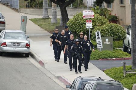 Police take positions at the scene of an armed standoff with a man with a high powered rifle who is holding hostages in Chula Vista, California May 28, 2015. REUTERS/Earnie Grafton