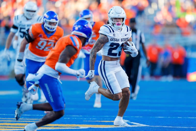 Utah State wide receiver Kyrese White (23) runs with the ball against the Boise State defense after a reception in the first half of an NCAA college football game, Saturday, Oct. 5, 2024, in Boise, Idaho. . (AP Photo/Steve Conner) | Steve Conner