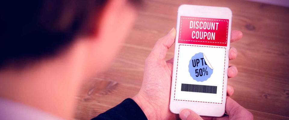 Businesswoman using phone at desk against sale advertisement