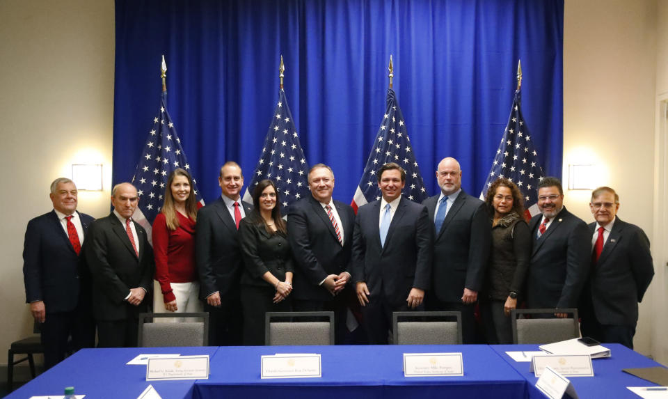 Secretary of State Mike Pompeo, center left, and Florida Gov. Ron DeSantis, center right, pose for a photo with participants of a roundtable discussion with Venezuelan exiles and other officials, Thursday, Jan. 23, 2020, in Miami. (AP Photo/Wilfredo Lee)