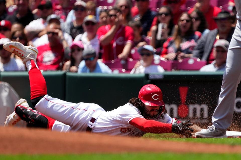 Cincinnati Reds second baseman Jonathan India (6) dives back to first base after hitting a single in the first inning during a baseball game between the St. Louis Cardinals and the Cincinnati Reds, Thursday, May 25, 2023, at Great American Ball Park in Cincinnati.