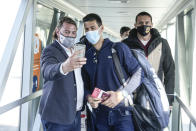 A man takes a selfie photograph with Serbian tennis player Novak Djokovic after his arrival in Belgrade, Serbia, Monday, Jan. 17, 2022. Djokovic arrived in the Serbian capital following his deportation from Australia on Sunday after losing a bid to stay in the country to defend his Australian Open title despite not being vaccinated against COVID-19.(AP Photo/Darko Bandic)