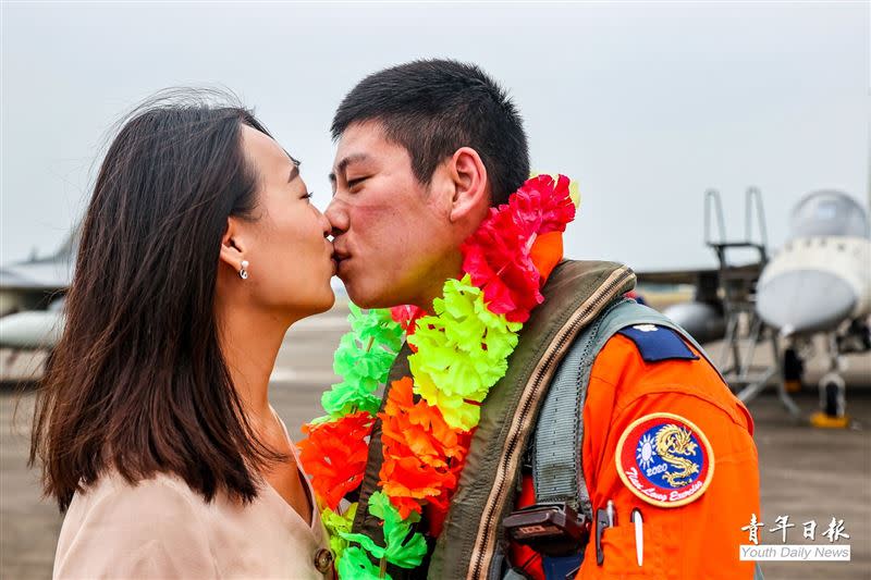 空軍第1聯隊8架IDF戰機昨日返回台南基地，飛行官歸來接受眷屬熱情的擁抱、親吻，並掛上歡迎凱歸的花圈。（圖／青年日報提供）